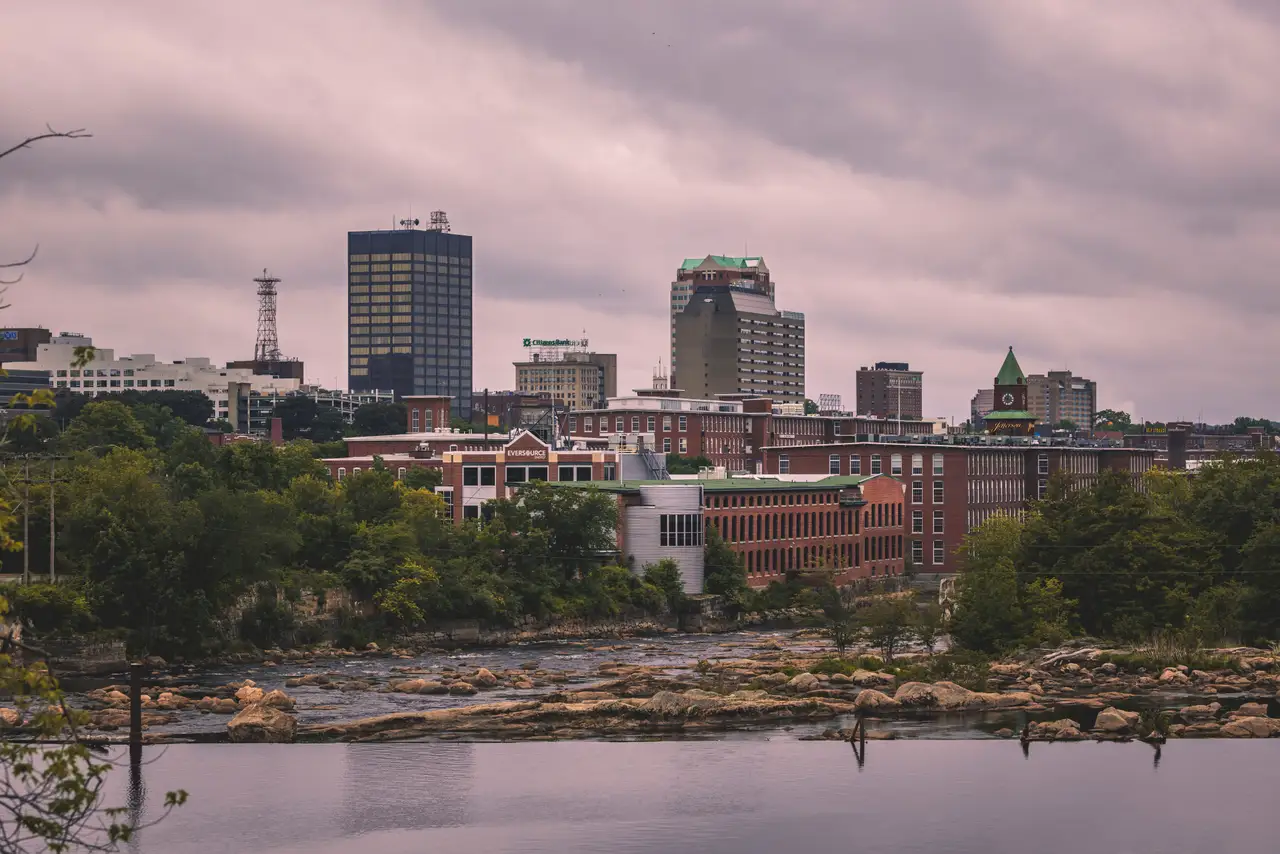 Fine-art photograph, “Manchester Skyline Along the Merrimack River Beneath Evening Clouds - RFIV0928.JPG,” from the New Hampshire collection.