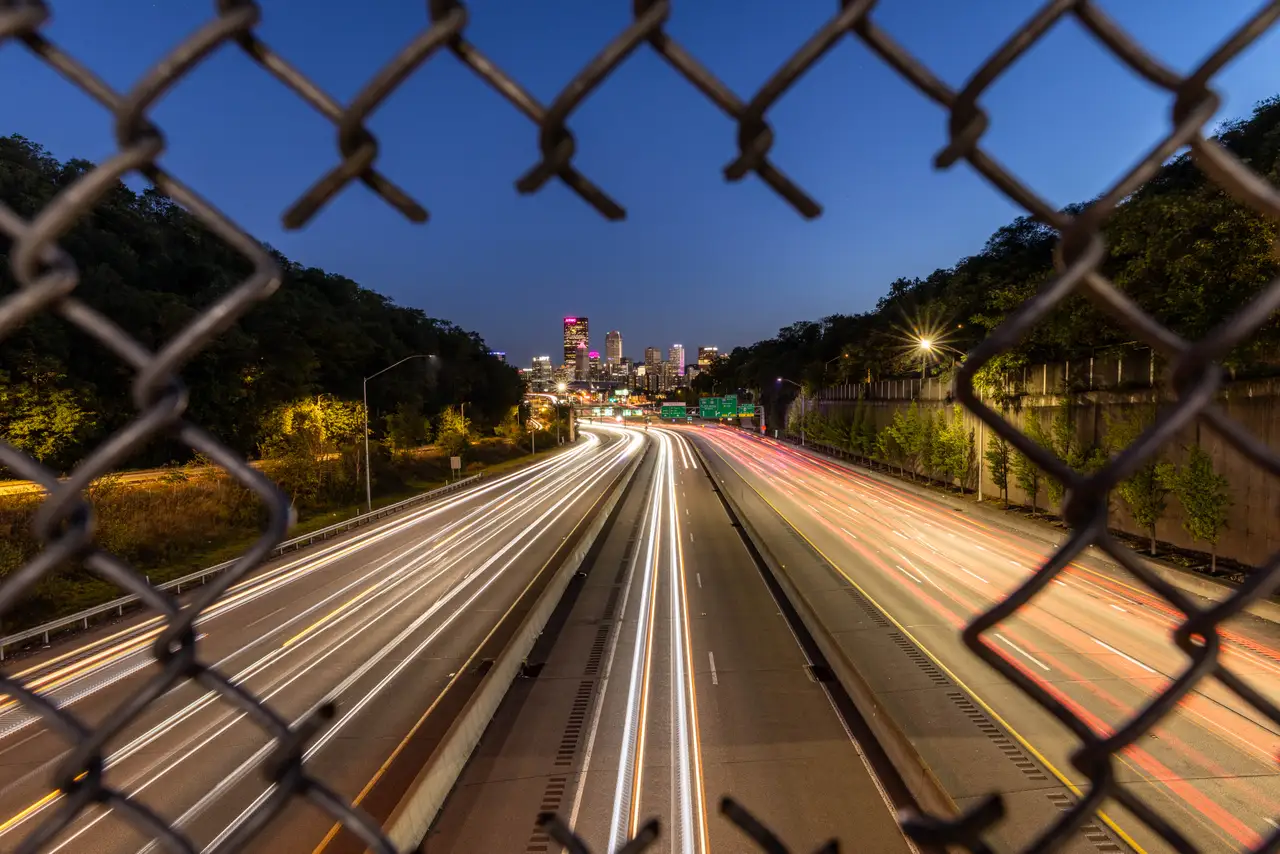 Fine-art photograph, “Pittsburgh Highway Light Trails Through a Fence, Urban Weather - 5M2A1523,” from the Pennsylvania - Pittsburgh collection.