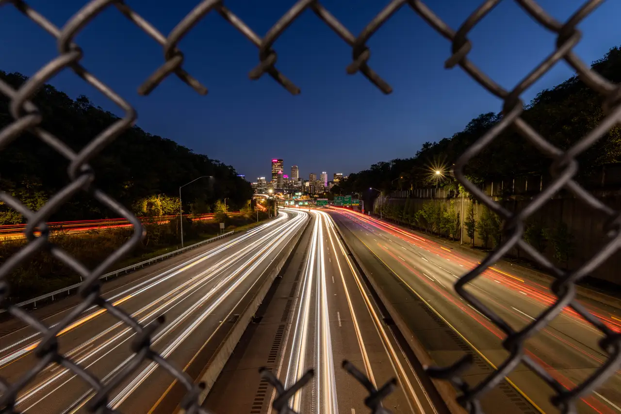 Fine-art photograph, “Pittsburgh Highway Light Trails Through a Fence, Dawn Traffic - 5M2A1524,” from the Pennsylvania - Pittsburgh collection.
